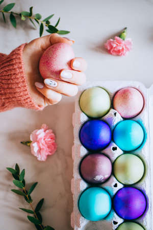 The girl is holding a pink easter egg on a stand, pink and marble background, minimalism, flowers