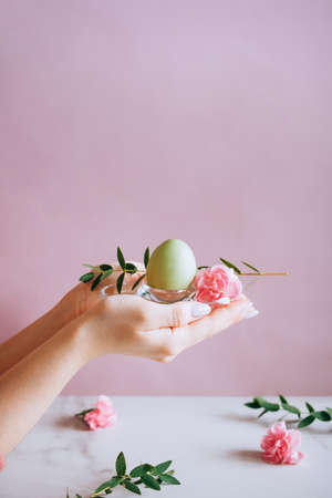 Hands painting modern style easter eggs with pink paintの写真素材