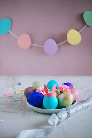 Colorfil easter egg, pink, green, blue, gold with bunny ears on marble background, minimalism,...