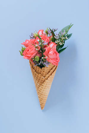 Flat lay Ice Cream Cones with colorful bouquet on blue background, copy spaceの写真素材