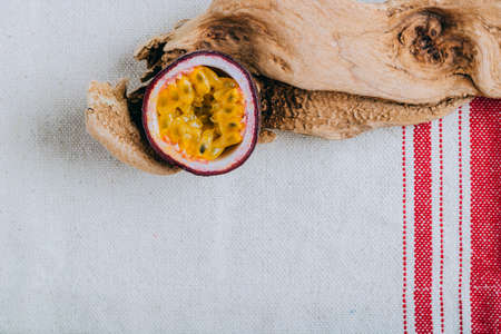 Sliced passion fruit in a dfift wood on linen napkin, tropical concept.の写真素材