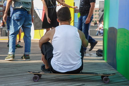 A guy is sitting on the skateboardの写真素材