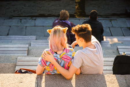 Young millennial couple on the waterfront, on the head of the girl's ears a character of Japanese animeの写真素材