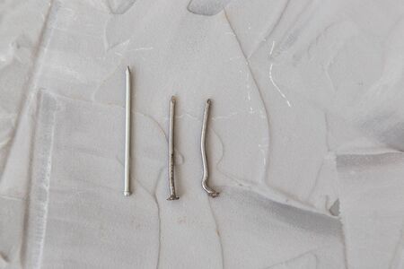 Old and new metal nails on gray background.の写真素材