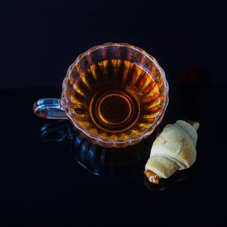 Homemade croissants with cherry jam and tea on the black table. flatlayの写真素材