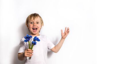 Portrait of the beautiful child holds a bouquet of blue flowers for her mother.の写真素材