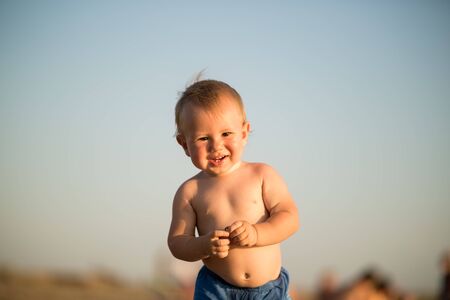 Little cute baby boy closeup portrait on sunset beach sunset.の写真素材