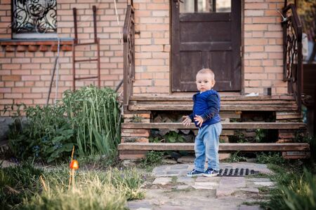 A child stands in the garden at the porch of the houseの写真素材