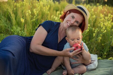 Mom and son in the summer field. Mother playing with her son.
