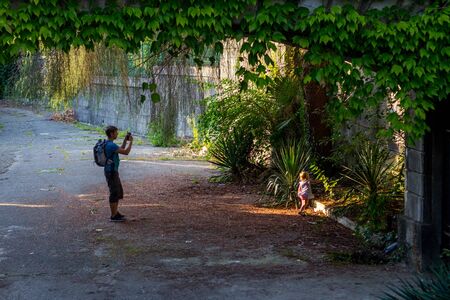 Little girl with her father among greenery