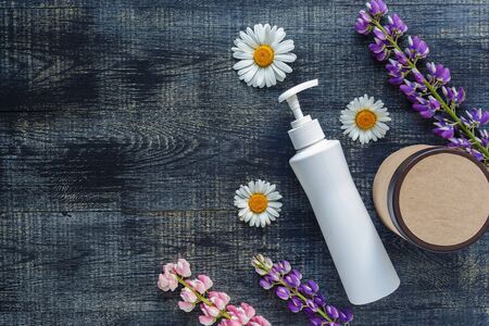 Cosmetic bottle containers with hermal camomile flowers Blank label for mock-upの写真素材