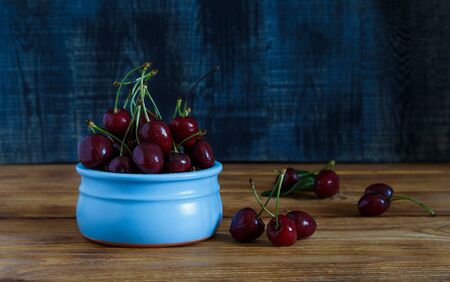 Fresh cherry on plate on wooden blue background.の写真素材