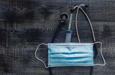 Still life made of stethoscope, syringe with a needle, medical face mask