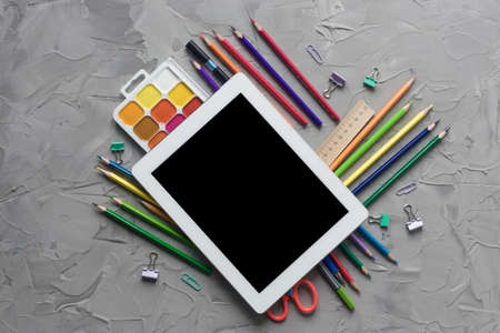 School supplies center composition on grey .concrete background