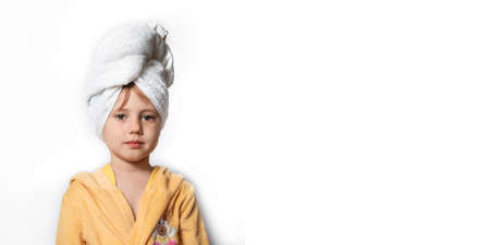 Cute girl in a yellow bathrobe with white towel to her hairの写真素材