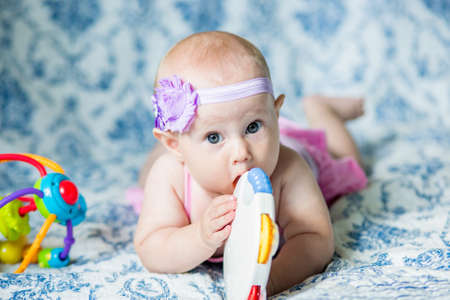 .7 month old baby girl on the bed looking at the camera