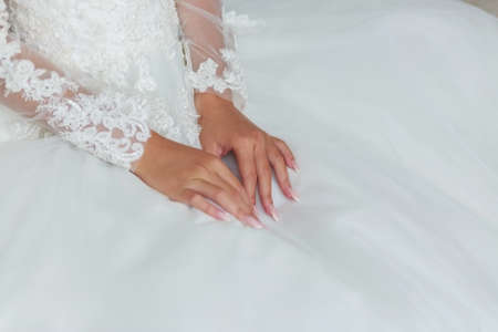 Brides hands on a wedding dresswhite wedding dressの写真素材