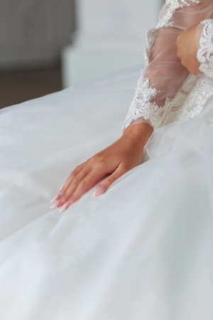 Brides hands on a wedding dresswhite wedding dressの写真素材