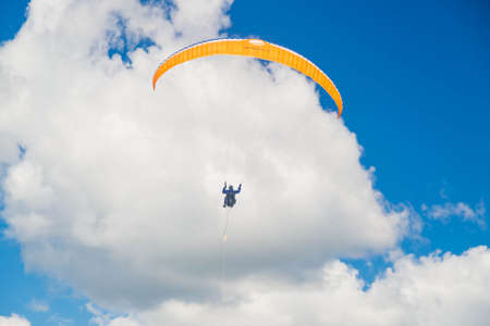 Tver, Russia - 9 august 2020: One paraglider is flying in the blue sky against the background of clouds. Paragliding in the sky on a sunny day.のeditorial素材