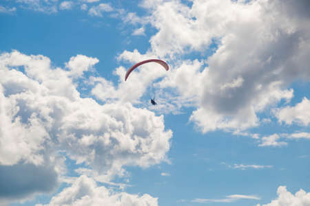 Tver, Russia - 9 august 2020: One paraglider is flying in the blue sky against the background of clouds. Paragliding in the sky on a sunny day.のeditorial素材