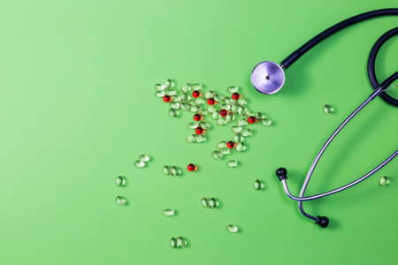 Covid-19, coronavirus treatment. Pills, stethoscope and medical masks on green background.の写真素材