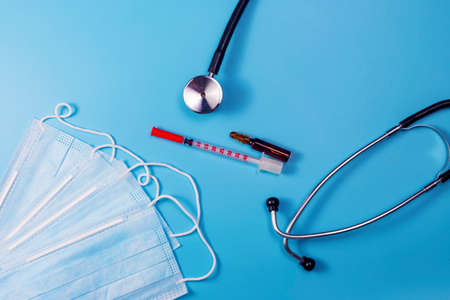 Covid-19, coronavirus treatment. Pills, stethoscope and medical masks on blue background.の写真素材