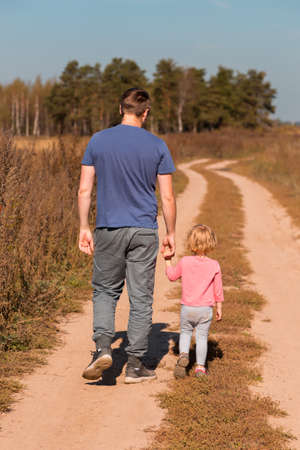 .happy family father and child on meadow holding hands of each other. summer vacation happy family concept.の写真素材