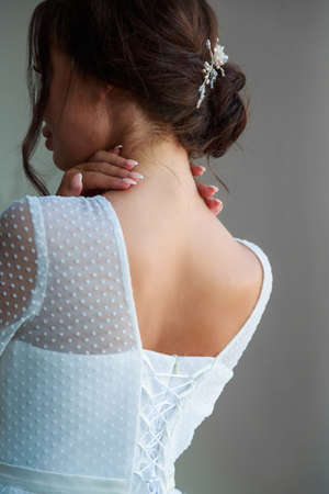 Bride in white wedding dress back view cropped portrait.