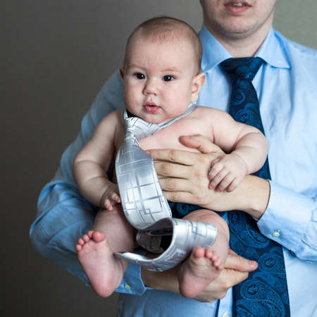close-up portrait of a toddler boy in the arms of dadの写真素材