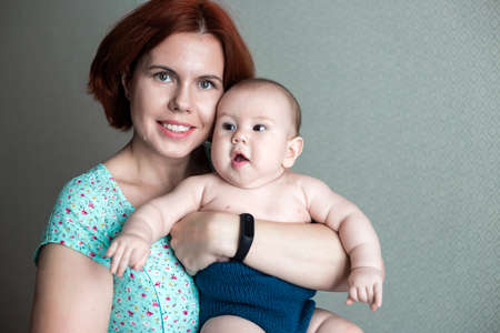 mom holds her little son in her arms.の写真素材