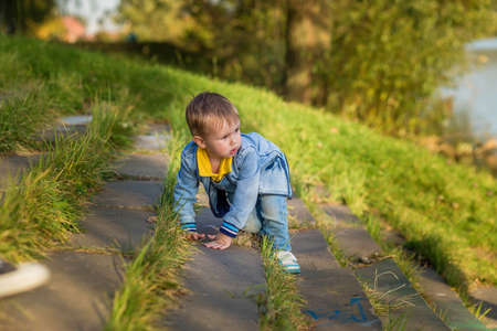 A little boy goes down the stairs in the public park one summer day