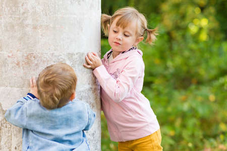 .Children play near the column in the old park on an autumn walkの写真素材