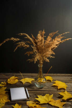 .Still life of autumn fallen leaves and office supplies on a wooden background.の写真素材