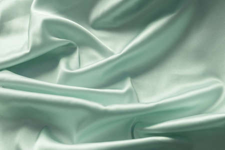 Smooth elegant green silk with soft folds can be used as background.の写真素材