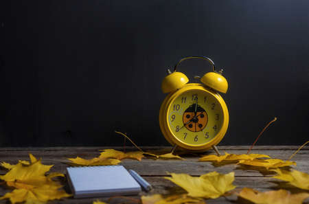 .Still life of autumn fallen leaves and office supplies on a wooden background.