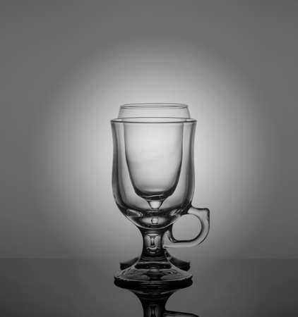 empty drink glasses placed one after another on dark background with back light.の写真素材