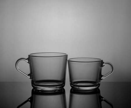 Empty tea cups on dark background with back light.の写真素材