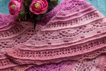 Crochet background flatlay. Bobbin of colored yarn, crochet hook, crochet scarf on a concrete...