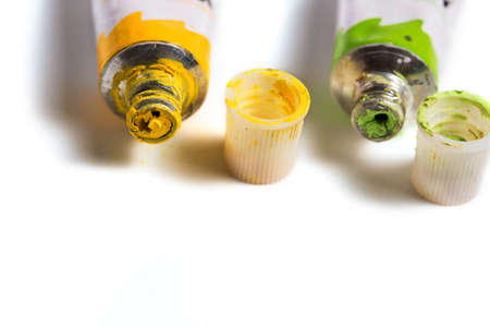 Dried green and yellow watercolor paint in a tube isolated on white background.