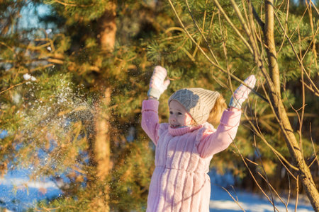 Little girl is Playing With Snow In Winter forest. Happy childhood.の写真素材