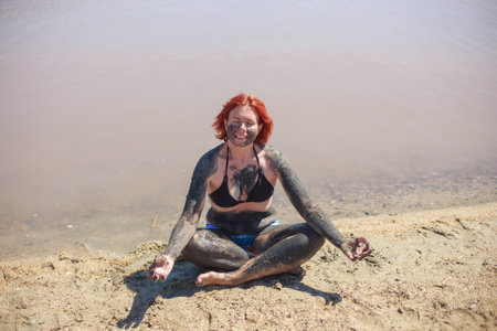 Young Woman is taking the Natural Mineral Mud On Face and body Sourced From The Sea