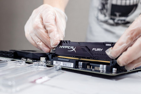 Moscow, Russia -25 Dec 2020: Installing ram memory module on desktop computer motherboard closeup