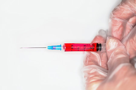 Close-up of a nurse releases air from a syringe with a medicine before injectionの写真素材
