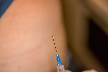 Close-up of a nurse releases air from a syringe with a medicine before injectionの写真素材