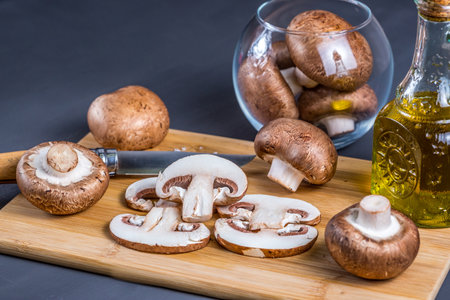 Royal champignons, Parisian champignons, mushrooms on bamboo wooden chopping board. Dark wooden background. Side view.の写真素材