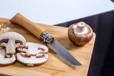 Royal champignons, Parisian champignons, mushrooms on bamboo wooden chopping board. Dark wooden background. Side view.の写真素材