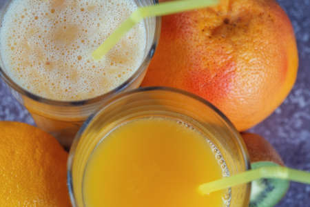 Top view of glasses of orange juice and banana kiwi and spinach smoothies.の写真素材
