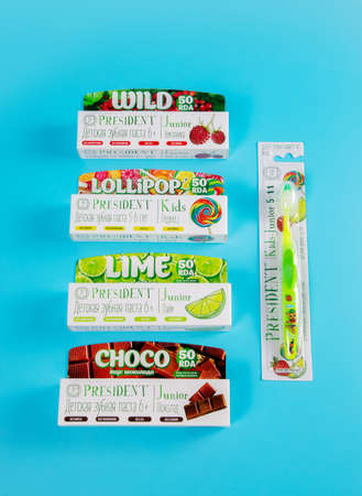 Moscow, Russia - 9th Matra 2021: Childrens toothpastes and a toothbrush on a blue background. The concept of proper oral care against bad breath, cavities and plaque. Dental care product.のeditorial素材