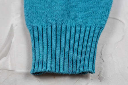 Close-up of knitted elastic blue sweater cuff.