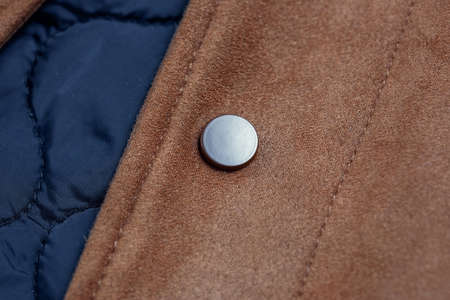 Close-up of a button-down button on a faux suede jacket.の写真素材